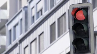 Modern bir binaya karşı parlak kırmızı bir trafik ışığı yakın çekim.