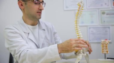 Profesyonel doktor sohbeti ve klinik bir tıbbi ortamda insan omurgasının anatomisi hakkında açıklama.