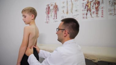 Genç bir çocuk, profesyonel bir klinik çevredeki bir doktordan sağlık muayenesi geçiriyor.