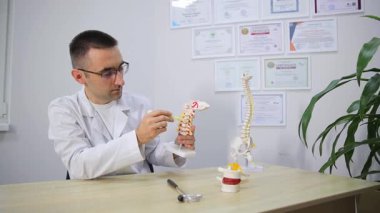 Bir tıp uzmanı, insan iskeletinin karmaşık yapısını vurgulayarak anatomik modeller sergiler.
