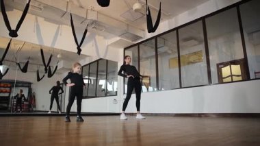 Beden eğitimi eğitmeni parlak bir stüdyoda bir çocuğu eğitiyor..