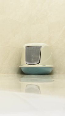 Zarif ve şık bir kedi kumu kutusu minimalist bir tasarımın yer aldığı düzenli bir banyoya mükemmel bir şekilde yerleştirilir.