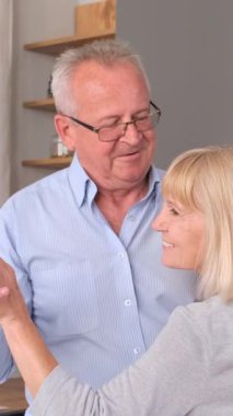 Son sınıf çifti evde dans ediyor. Dikey video.