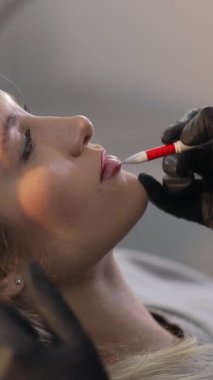 Klinik ortamda müşteriye dudak büyütme işlemi. Kozmetik tedavi.