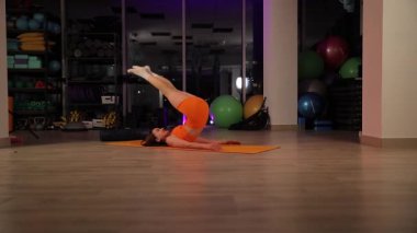 Atletik kız, çağdaş bir spor salonunda tam bir ayrılık gerçekleştiriyor..