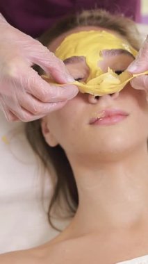 Müşteri, rahatlatıcı bir spa ziyareti sırasında besleyici bir bitkisel maskeyle rahatlatıcı bir yüz tedavisinden hoşlanır..