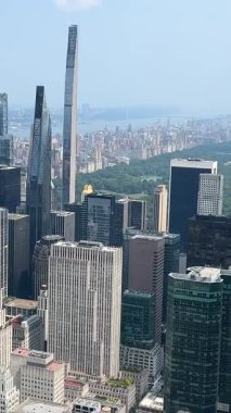 Güneşli bir günde New York 'un gökyüzü ve Central Park manzarasının tadını çıkarın. Bu video önemli işaretleri ve şehrin canlı atmosferini yakalar.