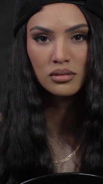 Dalgalı saçlı esmer kadın fotoğrafçıya poz veriyor. Dikey video.