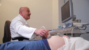 Tecrübeli bir doktor kapsamlı bir ultrason uygular ve gelişmiş tıbbi teknolojinin iş başında olduğunu gösterir.