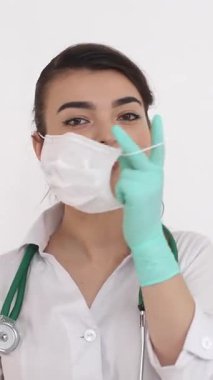 Maske ve eldiven takmış kendini adamış bir sağlık çalışanı hayati tıbbi görevleri yerine getirmeye hazırlanıyor..