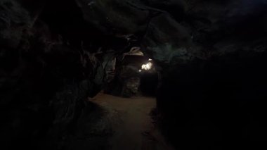 Loş ışıklı mağara yolunun büyüleyici ve büyüleyici bir görüntüsü.