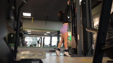 Kendini adamış ve kendini adamış bir birey canlı ve modern bir spor salonunda etkin bir şekilde egzersiz yapıyor.