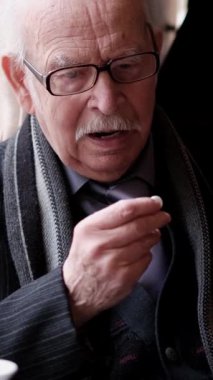 Yaşlı bir adam oturur ve bir hap alır. Yüzü, yaşla gelen derin düşünceleri ve bilgeliği açığa çıkarır..