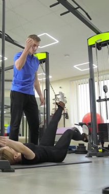 Kişisel antrenör, spor salonunda müşteriye doğru egzersiz tekniğine ve egzersizler sırasında forma odaklanması için yardım eder.
