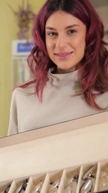 Şık optik mağazada canlı gözlük koleksiyonu gösteren dikey video modeliName.