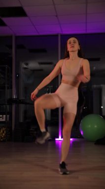 Ayakta bölünmüş, esneklik gösteren bir kadın. Dikey video.