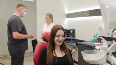 Bir hasta, deneyimli profesyonellerle danışmanlık yaparken diş hekimliği koltuğunda rahatça oturabilir.