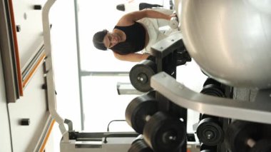 Fitness kadını modern ve yenilikçi bir spor salonunda büyük bir hevesle güç antrenmanı yapıyor..