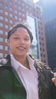 Kendine güvenen, hırslı Afrikalı Amerikalı bir kadın şehrin ortasında duruyor, profesyonellik ve benzersiz bir stil yayıyor..