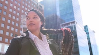 Afro-Amerikalı, hırslı bir kadın. Meşgul bir şehir caddesinde gururla duruyor. Şehir yaşamını ve başarı hırsını simgeliyor..