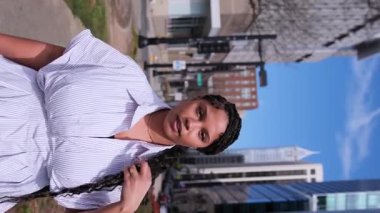 Modern mimariyle çevrili kentsel bir çevrede yürüyen şık Afrikalı Amerikalı iş kadını..