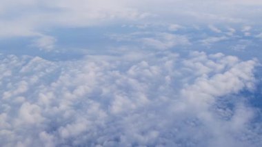 Tüylü beyaz bulutların dingin güzelliğini gösteren hava manzarası sükunetle dolu açık mavi bir gökyüzüne karşı..