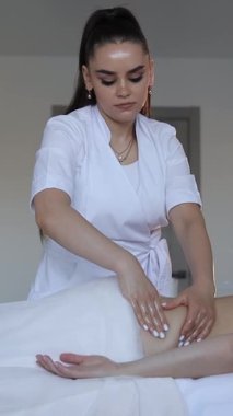 Hastanedeki hastaya terapötik sırt masajı yapan profesyonel bir masör. Dikey video.