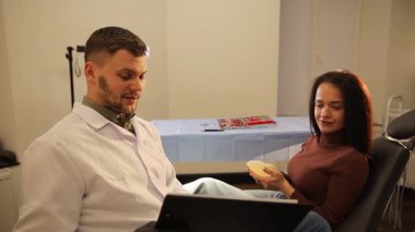 Modern ofis ortamında bir doktor ve hasta arasında sakin ve bilgilendirici bir danışma gerçekleşir. Kozmetik cerrahı