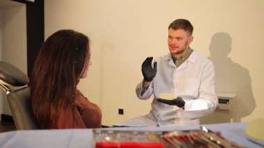 Nitelikli bir cerrah modern bir klinikte bir kadının göğüslerini tedavi etme prosedürünü açıklar, rahatlık ve anlayış sağlar.