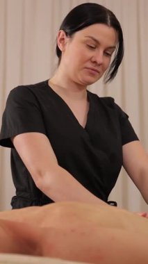 Kadın gençleşmenin tadını çıkarırken, yetenekli bir terapistle spa masajı yapmak. Sağlık ve kendine bakıcılık. Dikey video.