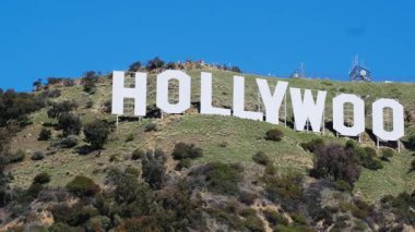 İkonik Hollywood tabelası bir tepenin üstünde gururla duruyor, eğlence endüstrisinin önemli bir sembolü olarak hizmet veriyor..