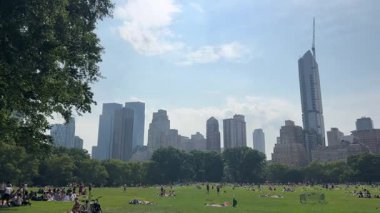 Central Park 'ın nefes kesici ve çarpıcı manzarası, açık mavi gökdelenlerin karşısında güzel bir şekilde sergilenen gökdelenler..