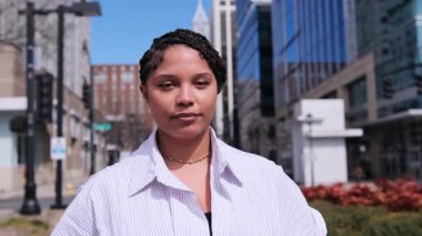 Kendine güvenen, güzel Afro-Amerikan kadın yüksek binaların arka planında caddede yürüyor. Özgür insanlar kavramı