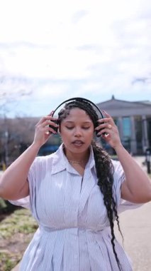 Güzel bir genç kadın açık bir bahar gününde sokakta müzik dinleyerek yürüyor. Yürüyorum, müziğin tadını çıkarıyorum..