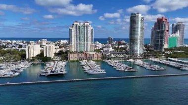 Miami 'nin kıyı şeridinden bir görüntü. Açık bir gökyüzü ve okyanusun arka planına karşı Miami gökdelenleri
