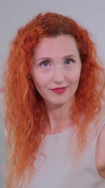 Muhteşem, canlı kızıl saçlı kendine güvenen bir kadın zarif bir şekilde poz verir, gururla doğal güzelliğini sergiler.