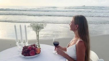 Kadınlar okyanus kıyısındaki sakin ve huzurlu atmosferin tadını çıkarırlar. Güzel şarap ve taze meyvelerle..