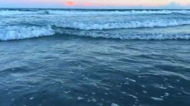 Gün batımında güzel okyanus dalgaları ruhu cezbeden sakin ve sakin bir kıyı manzarası yaratır.