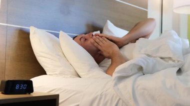 Bir adam mizahi bir şekilde yataktan çıkmak için çabalıyor, bir otel odasında bir çok güzel sabah anını yakalıyor..