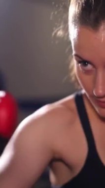 Kararlı bir dişi boksör, gücünü göstererek ve sınırlarını zorlarken odaklanarak yoğun bir şekilde antrenman yapar.