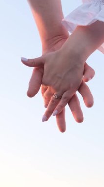 Romantik bir yakın çekim, iki el tutuşması, bir nişan yüzüğü, aşkı ve bağı simgeliyor..