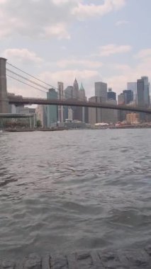 Günbatımında Manhattan Köprüsü ile New York silueti. Dikey video.