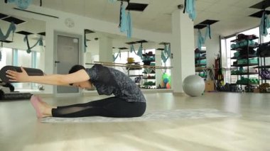 Modern bir stüdyo ortamında çeşitli ekipmanlar kullanarak esnek bir yoga pozisyonu deniyorum..