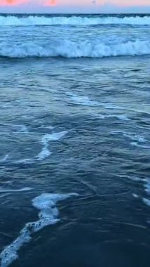 Gün batımında süzülen yumuşak okyanus dalgalarının huzurlu manzarası doğanın çarpıcı güzelliğini yakalıyor..