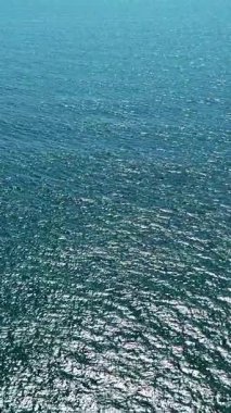 Okyanus dalgaları parlak güneş ışığını güzel yansıtıyor, doğanın saf güzelliğini sergiliyor..