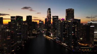 Miami 'nin gece iş merkezinin tepesinden inanılmaz güzel bir çekim. Gün batımında, alacakaranlıkta, tepeden Megalopolis. Büyük bir şehrin gece hayatı.