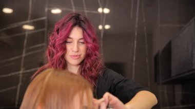 Yetenekli bir kuaför, lüks bir kuaförde yaratıcı stil teknikleri ve canlı saç renkleri sergiler.