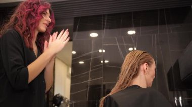 Yetenekli bir kuaför modern bir kuaför ortamında eşsiz saç stili teknikleri gösterir.