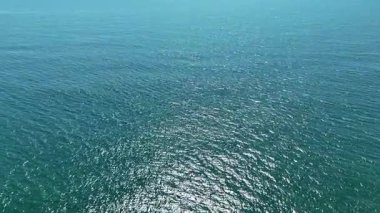 Parlak mavi gökyüzünün altındaki ışıl ışıl okyanus sularının sakin manzarası, rahatlama ya da doğa temalı projeler için mükemmel..