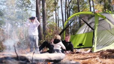 Mutlu bir aile, çadırın yanında kamp yaparken eğleniyor. Çadırda dinlen..